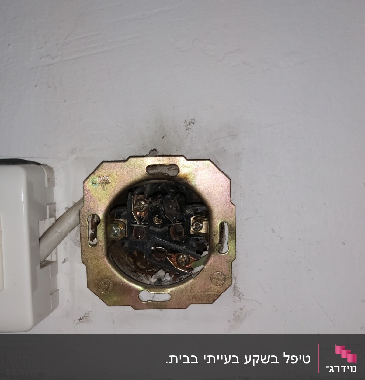 שקע חשמלי פתוח עם חוטים חשופים בקיר